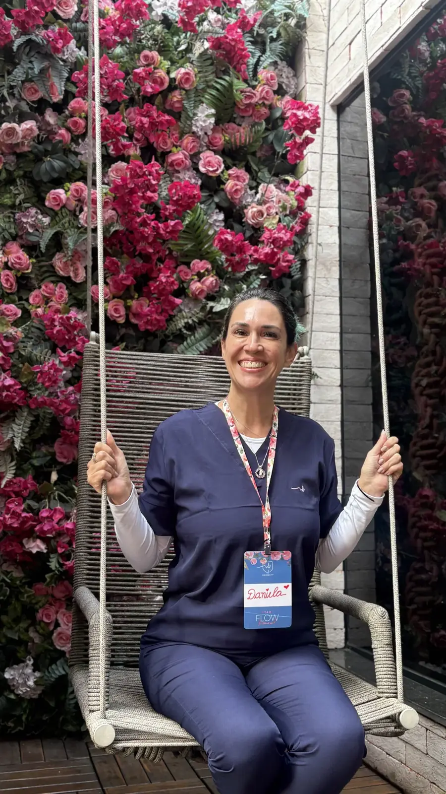 Daniela Rodrigues sorrindo em um balanço durante o curso Flow Removal, na clínica NaBeauty